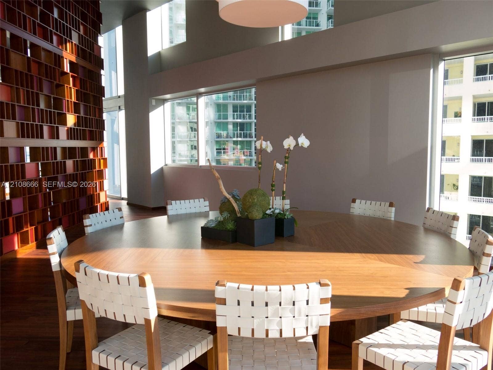 1300 Brickell Bay Drive, #3506, Miami, FL 33131 Double-height ceilings, floor-to-ceiling windows, and a floor-to-ceiling custom geometric wood-slat feature wall accented by wood-finish flooring