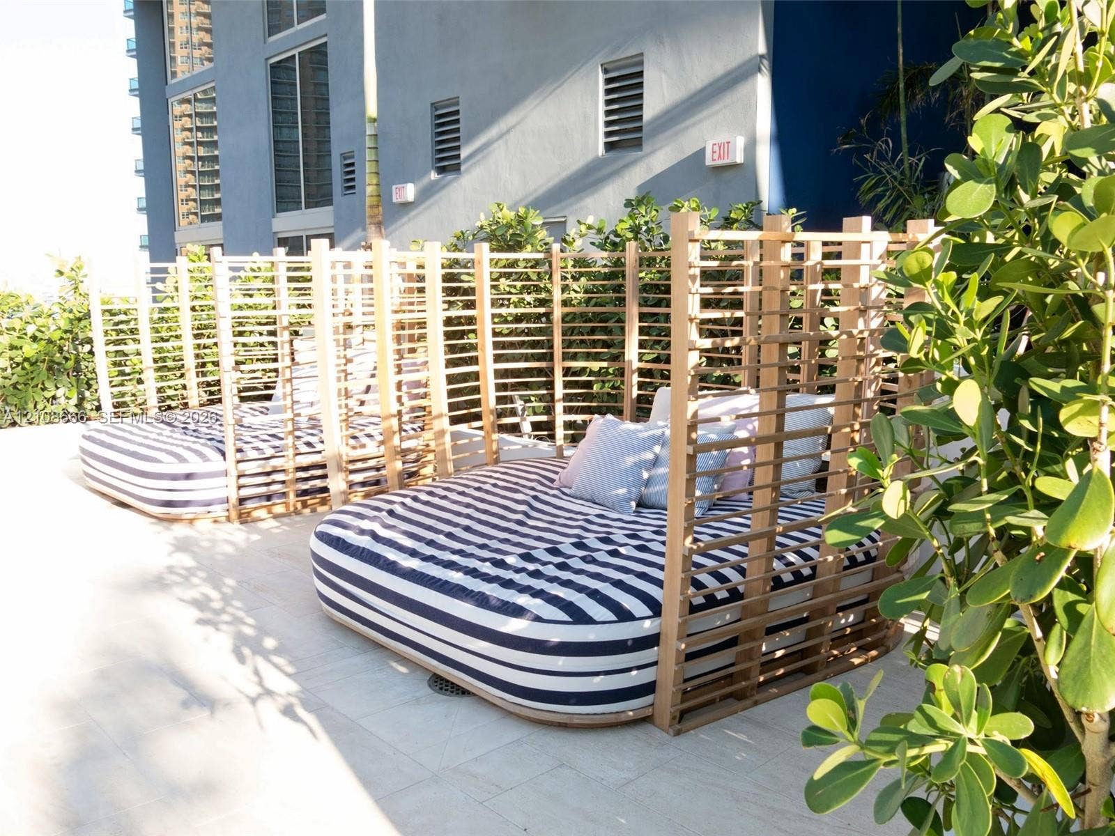 1300 Brickell Bay Drive, #3506, Miami, FL 33131 Outdoor terrace featuring stone tile flooring, custom slatted wood privacy structures, and integrated landscaping