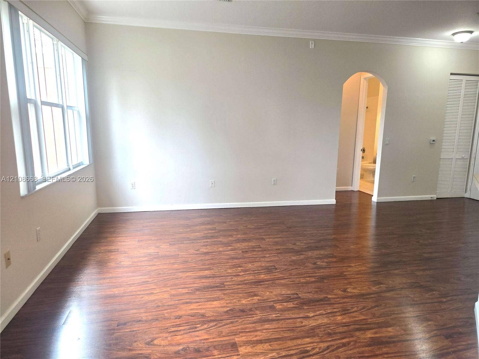 4508 SW 160th Avenue, #734, Miramar, Miramar, FL 33027 Wood-finish flooring, neutral wall tones, crown molding, multi-pane windows, and a classic arched doorway