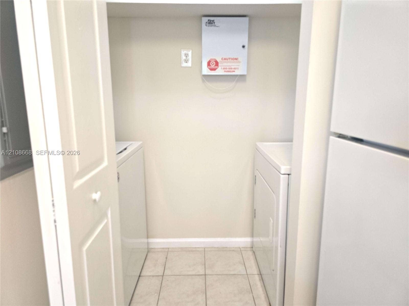 4508 SW 160th Avenue, #734, Miramar, Miramar, FL 33027 Utility closet featuring tiled flooring, bi-fold doors, and a wall-mounted security panel