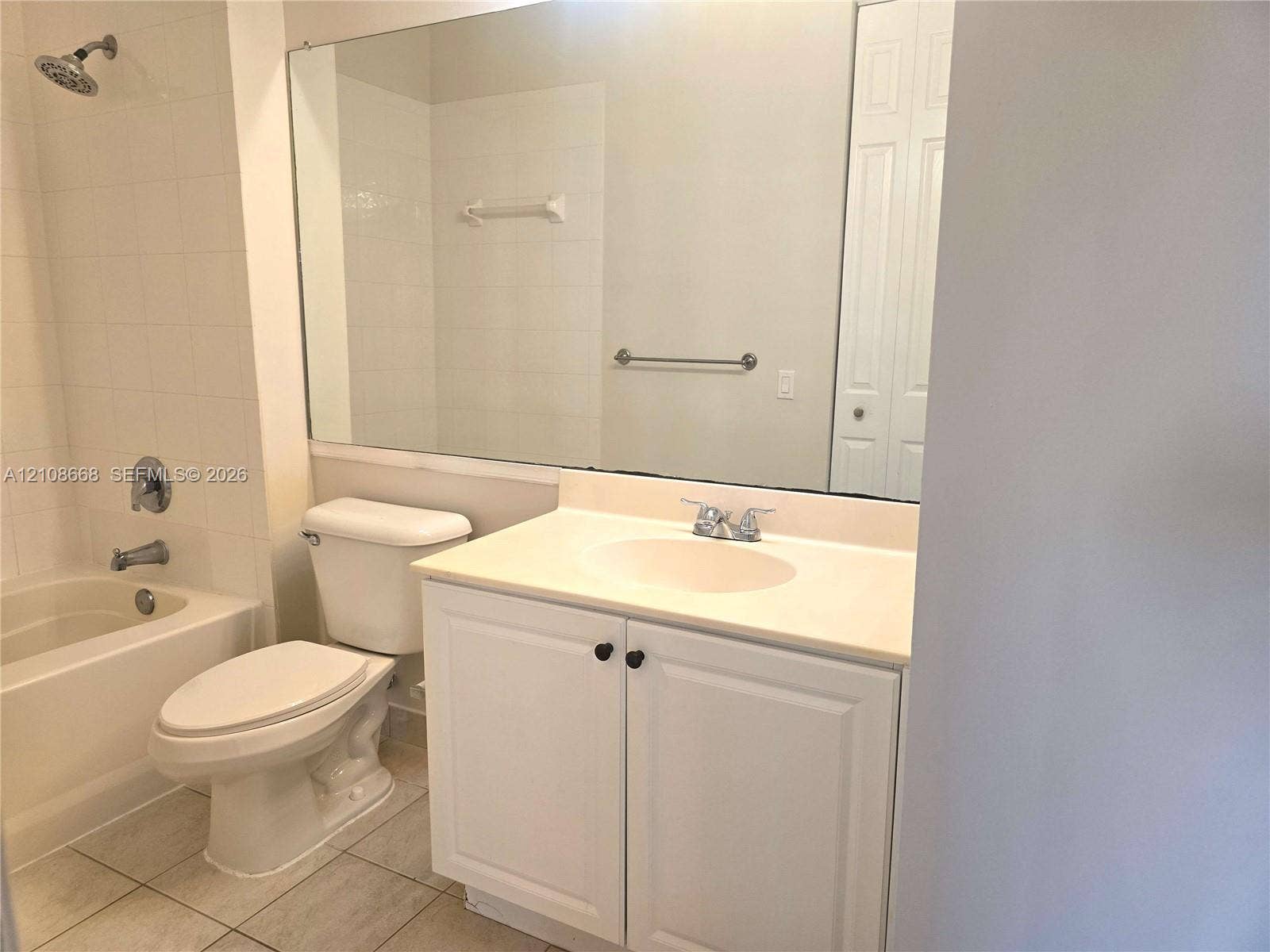 4508 SW 160th Avenue, #734, Miramar, Miramar, FL 33027 Bathroom featuring a white vanity cabinet, solid-surface countertop with an integrated sink, full-width wall mirror, and a tile-surround combination tub and shower