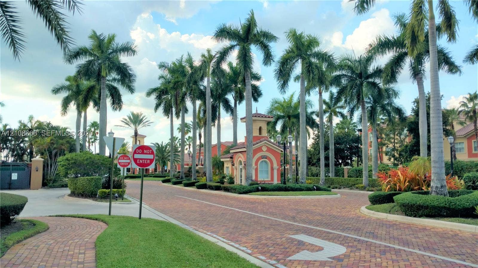 4508 SW 160th Avenue, #734, Miramar, Miramar, FL 33027 Gated community entrance featuring paver-stone roadways, established palm tree landscaping, and a Mediterranean-style guard pavilion