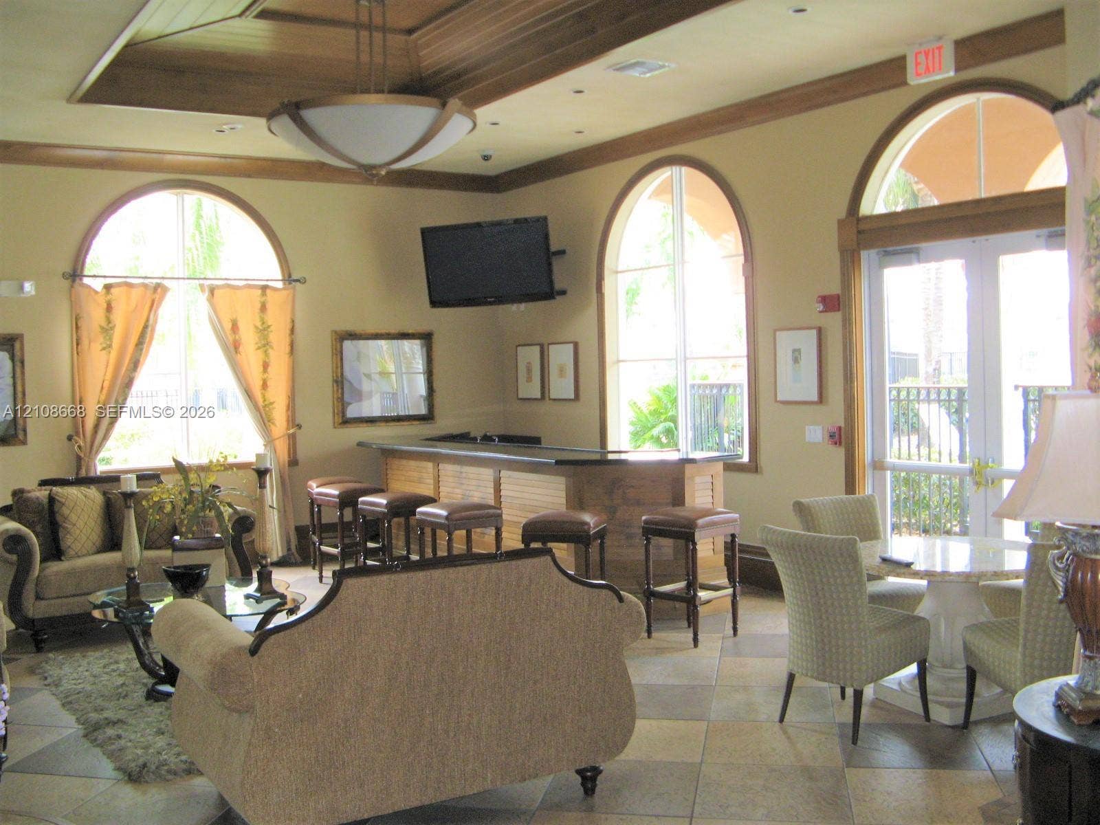 4508 SW 160th Avenue, #734, Miramar, Miramar, FL 33027 Tray ceiling with recessed lighting, arched windows, tile flooring, and a built-in bar with dark stone countertop