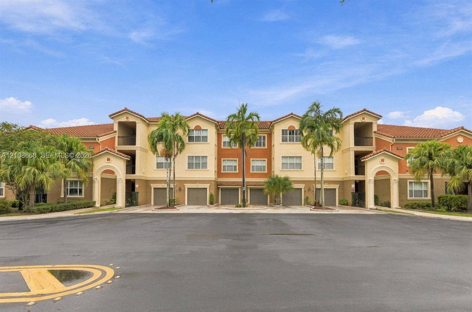4508 SW 160th Avenue, #734, Miramar, Miramar, FL 33027 Multi-story exterior featuring a Mediterranean-style tile roof, stucco facade, arched entryway detailing, and multiple integrated garage bays