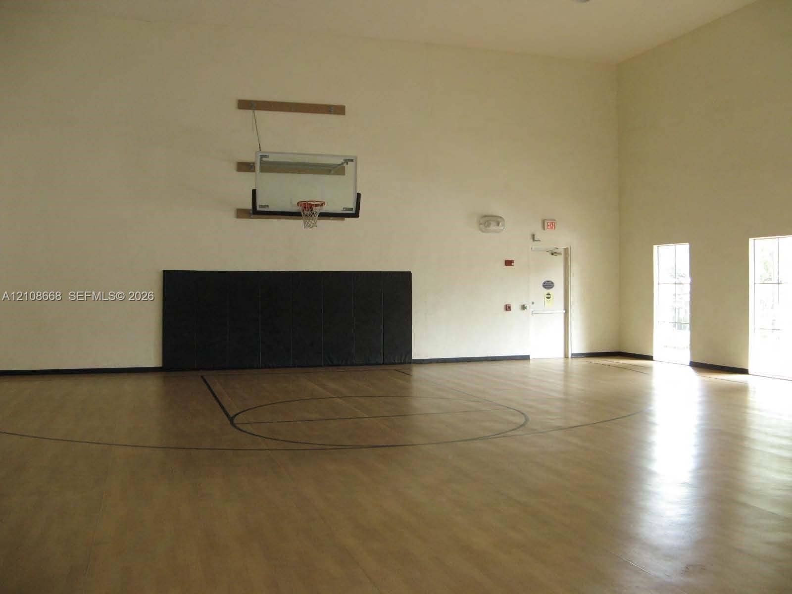 4508 SW 160th Avenue, #734, Miramar, Miramar, FL 33027 Indoor sports court featuring high ceilings, wood-finish flooring, a wall-mounted basketball hoop, and protective wall padding