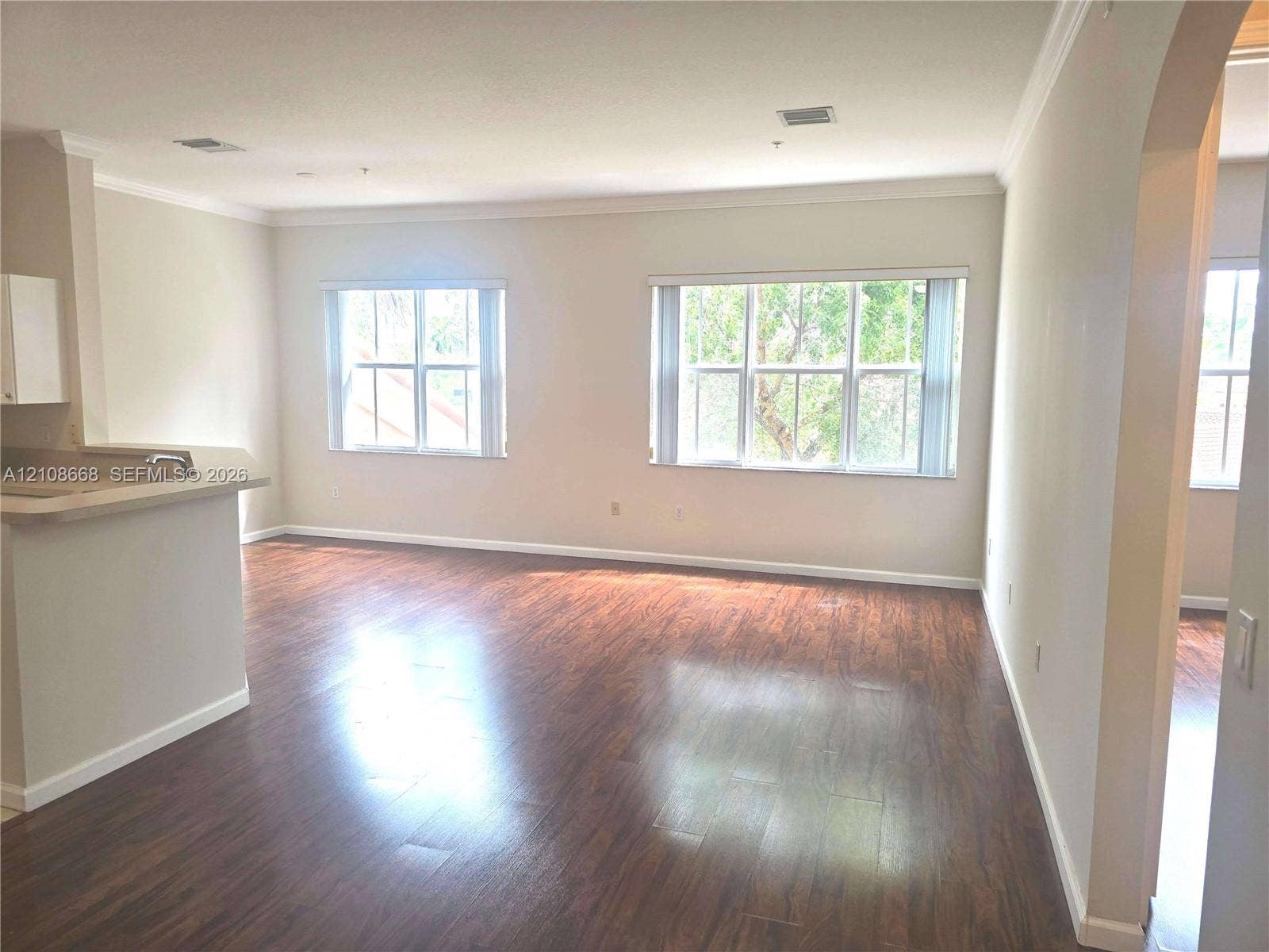 4508 SW 160th Avenue, #734, Miramar, Miramar, FL 33027 Open interior featuring wood-finish flooring, crown molding, double-pane windows, and a pass-through counter