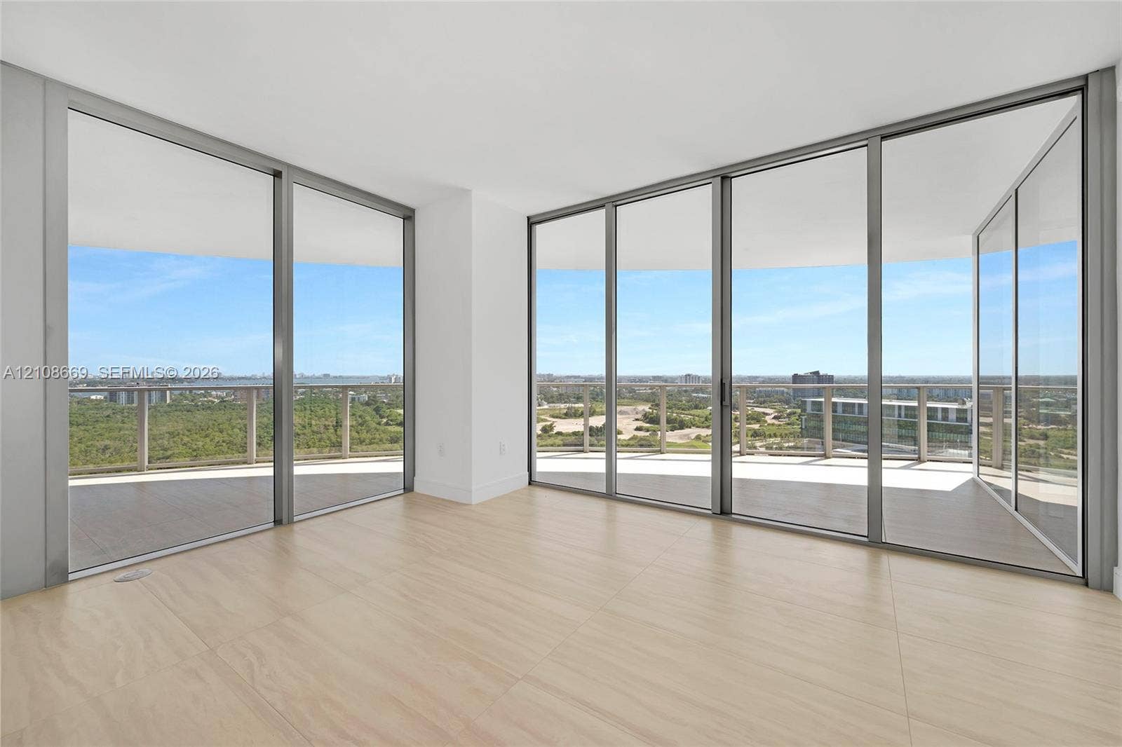Floor-to-ceiling glass walls, wrap-around balcony, expansive exterior railing, and wood-finish flooring