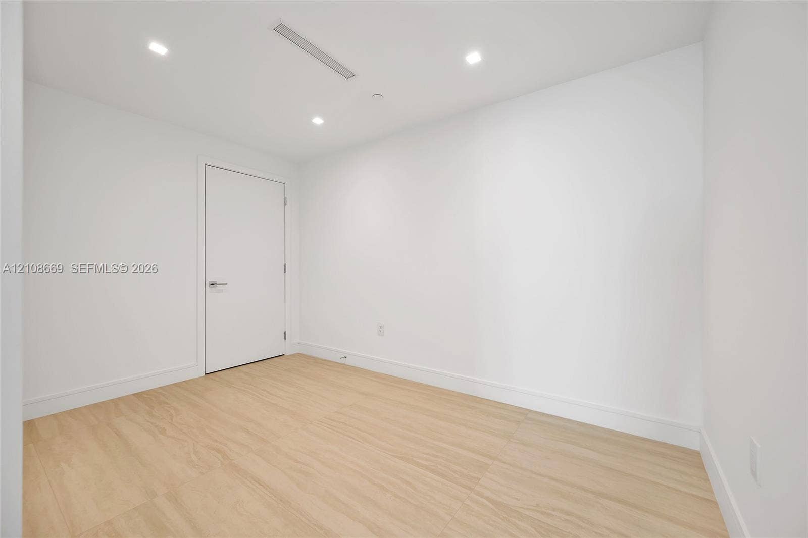 Neutral-toned wood-finish flooring, recessed ceiling lighting, and crisp white wall finishes