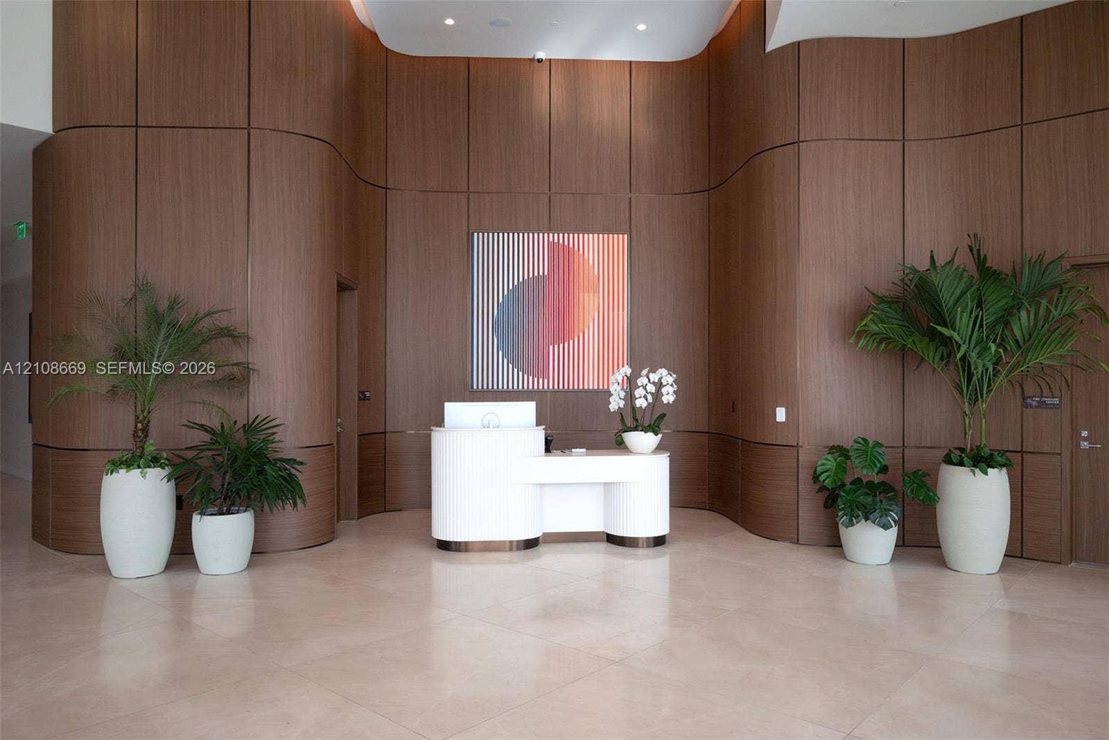 Curved wood-paneled feature wall, polished stone flooring, and custom reception desk