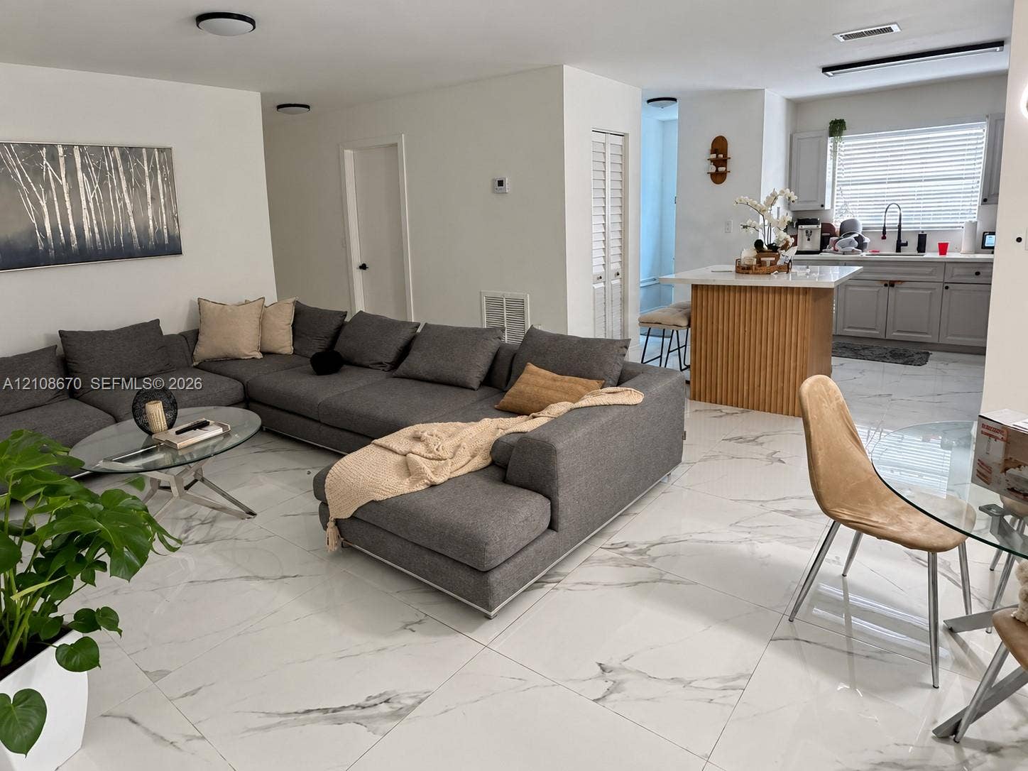 3435 SW 91st Avenue, #1, Miami, Miami, FL 33165 Open-concept interior featuring large-format tile flooring, a kitchen island with fluted wood-finish cabinetry, light gray shaker-style kitchen cabinetry, and recessed ceiling lighting