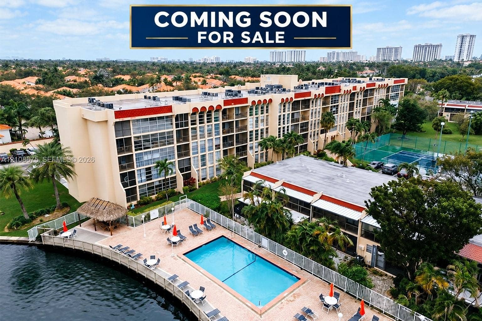 2001 Atlantic Shores Boulevard, #407, Hallandale Beach, FL 33009 Multi-story residential complex featuring a swimming pool, paved sundeck, and tennis courts.