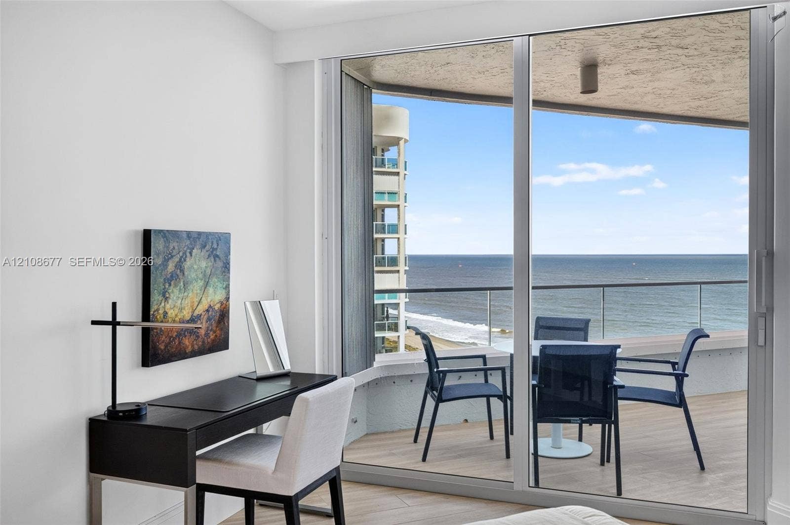 1440 S Ocean Boulevard, #11A, Lauderdale By The Sea, FL 33062 Full-height sliding glass doors opening to a private balcony with glass railing, wood look plank porcelain flooring, and ocean scenery. Double layered (light filtering and room darkening) remote operated window shades by Bandalux