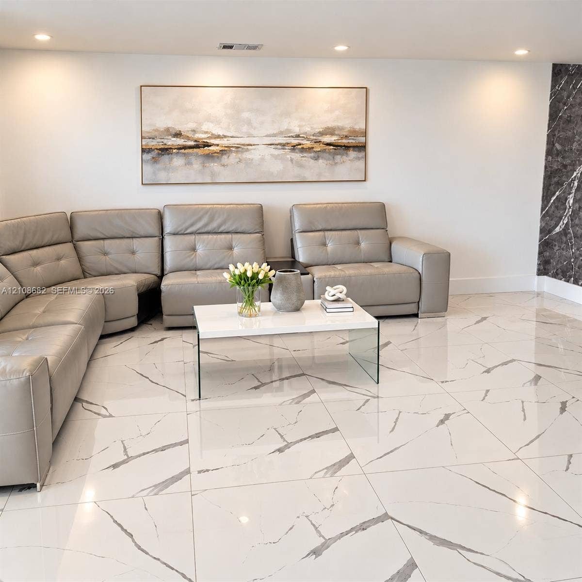 8943 NW 112th Terrace, Hialeah Gardens, FL 33018 Polished large-format floor tiles featuring a white base with dark veining, recessed ceiling lighting, and a dark stone-finish accent wall