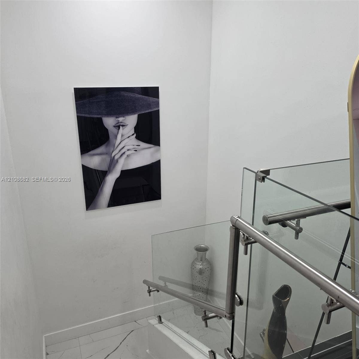 8943 NW 112th Terrace, Hialeah Gardens, FL 33018 Staircase featuring a frameless glass railing with polished metal hardware and tile flooring