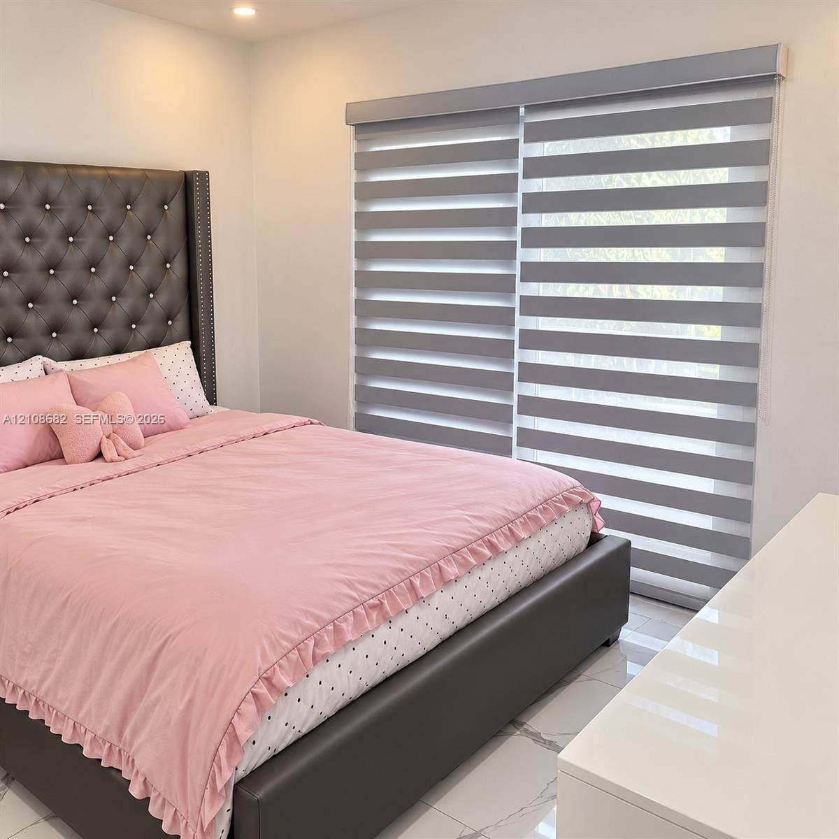 8943 NW 112th Terrace, Hialeah Gardens, FL 33018 Recessed ceiling lighting, large-format polished tile flooring, and layered zebra roller shades