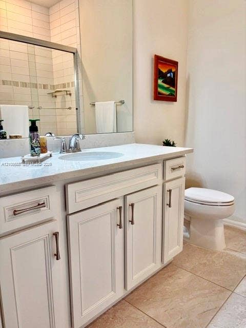 White cabinetry with brushed-metal hardware, quartz countertop, undermount sink, large vanity mirror, and tile flooring