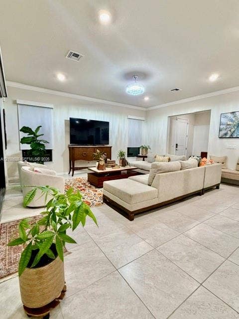 Neutral-toned large-format tile flooring, recessed ceiling lighting, crown molding, and a crystal-accented chandelier