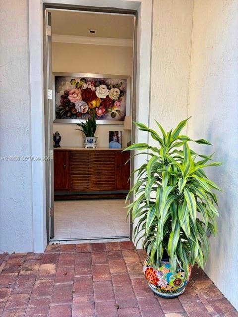 Entryway featuring red brick pavers, neutral wall finishes, and recessed ceiling lighting