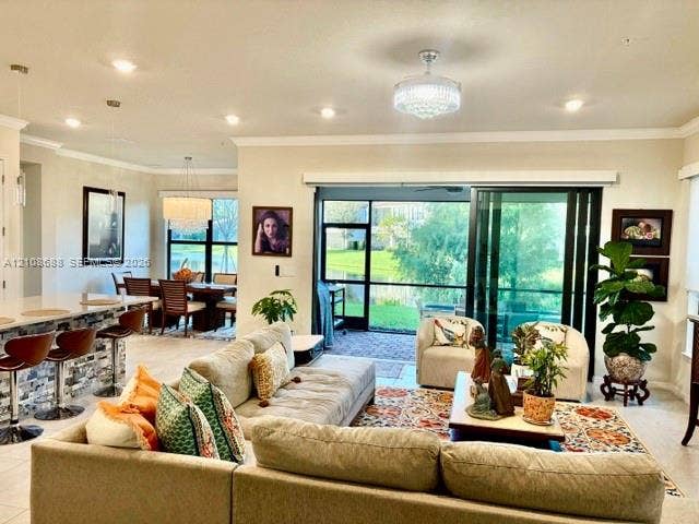 Open-concept interior featuring recessed lighting, a stone-accented kitchen island, multi-panel sliding glass doors, and dual crystal-style chandeliers
