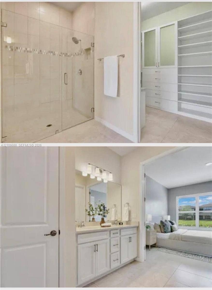 Walk-in shower with a glass enclosure, built-in floor-to-ceiling cabinetry, vanity with dual sinks, large wall mirror, and neutral tile flooring