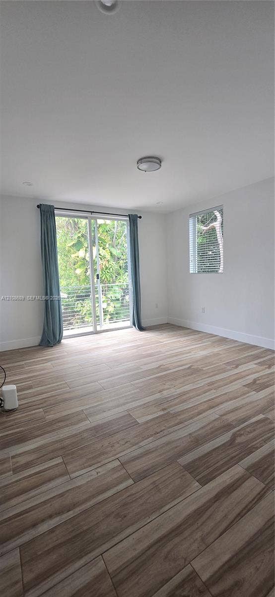 Miami, Miami, FL 33133 Room featuring wood-finish flooring, sliding glass door with metal railing, and recessed ceiling lighting