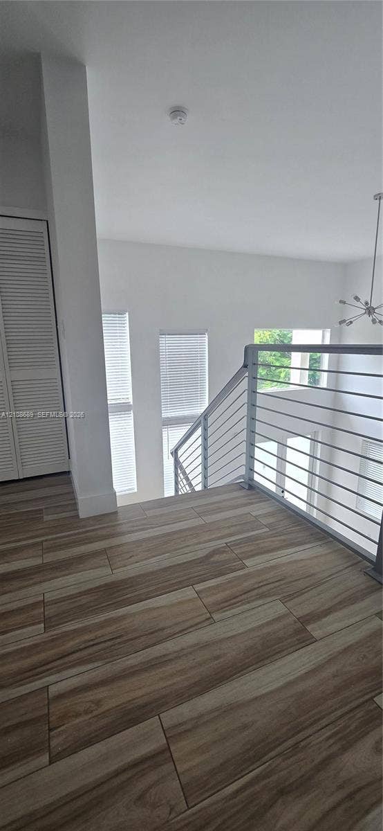 Miami, Miami, FL 33133 Landing area featuring wood-finish flooring, a horizontal cable railing system, tall windows, and a closet with louvered doors