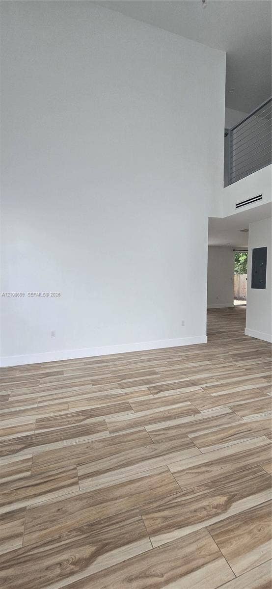Miami, Miami, FL 33133 High-ceiling interior space featuring wood-finish flooring and a metal railing mezzanine