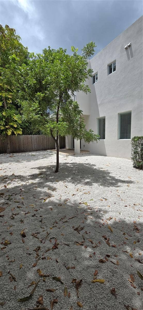 Miami, Miami, FL 33133 Exterior yard space featuring a white gravel ground cover, mature landscaping, and a wood-slat privacy fence