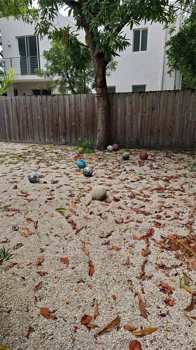 Miami, Miami, FL 33133 Backyard featuring white gravel ground cover, a wood privacy fence, and a mature tree