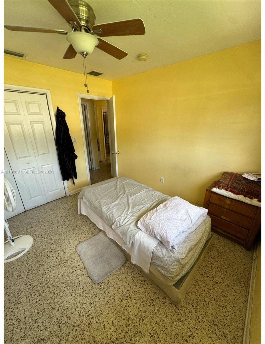 17210 NW 47th Avenue, Miami Gardens, FL 33055 Interior space featuring terrazzo flooring, ceiling-mounted fan with integrated lighting, and dual-panel closet doors