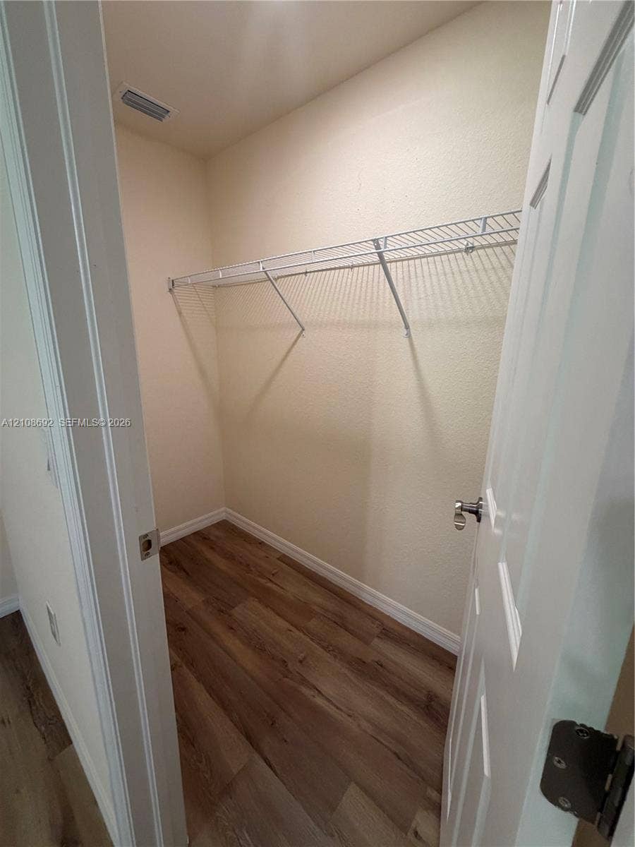 Walk-in closet featuring wood-finish flooring and white wire shelving