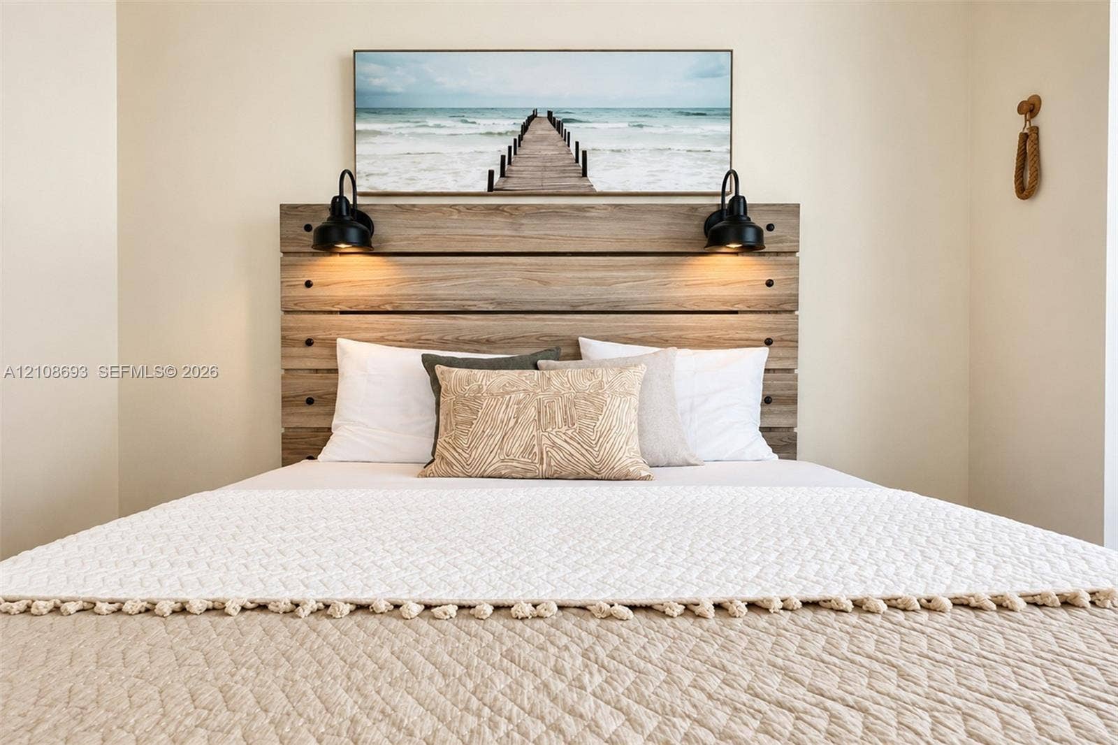 231 Riverside Drive, #1210, Daytona Beach, Daytona Beach, FL 32117 Custom built-in wood-finish headboard featuring matte black hardware and dual wall-mounted matte black sconce lighting