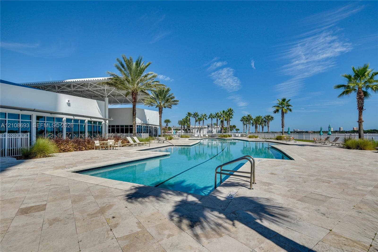 231 Riverside Drive, #1210, Daytona Beach, Daytona Beach, FL 32117 Swimming pool with integrated steps, surrounded by a stone-paved deck and palm trees