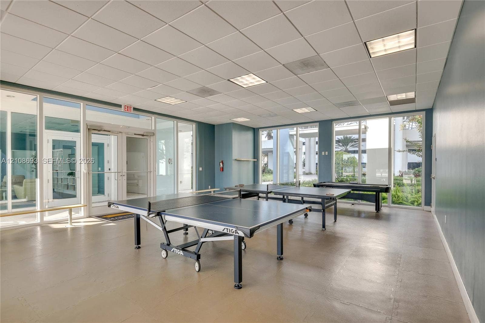 231 Riverside Drive, #1210, Daytona Beach, Daytona Beach, FL 32117 Open-concept multi-use space featuring full-height glass walls, recessed drop-ceiling grid lighting, and durable flooring