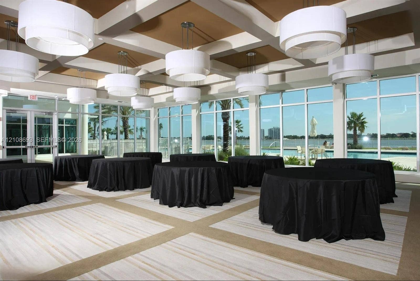 231 Riverside Drive, #1210, Daytona Beach, Daytona Beach, FL 32117 Coffered ceiling with tiered drum pendant lighting, floor-to-ceiling windows, and wall-to-wall carpeting