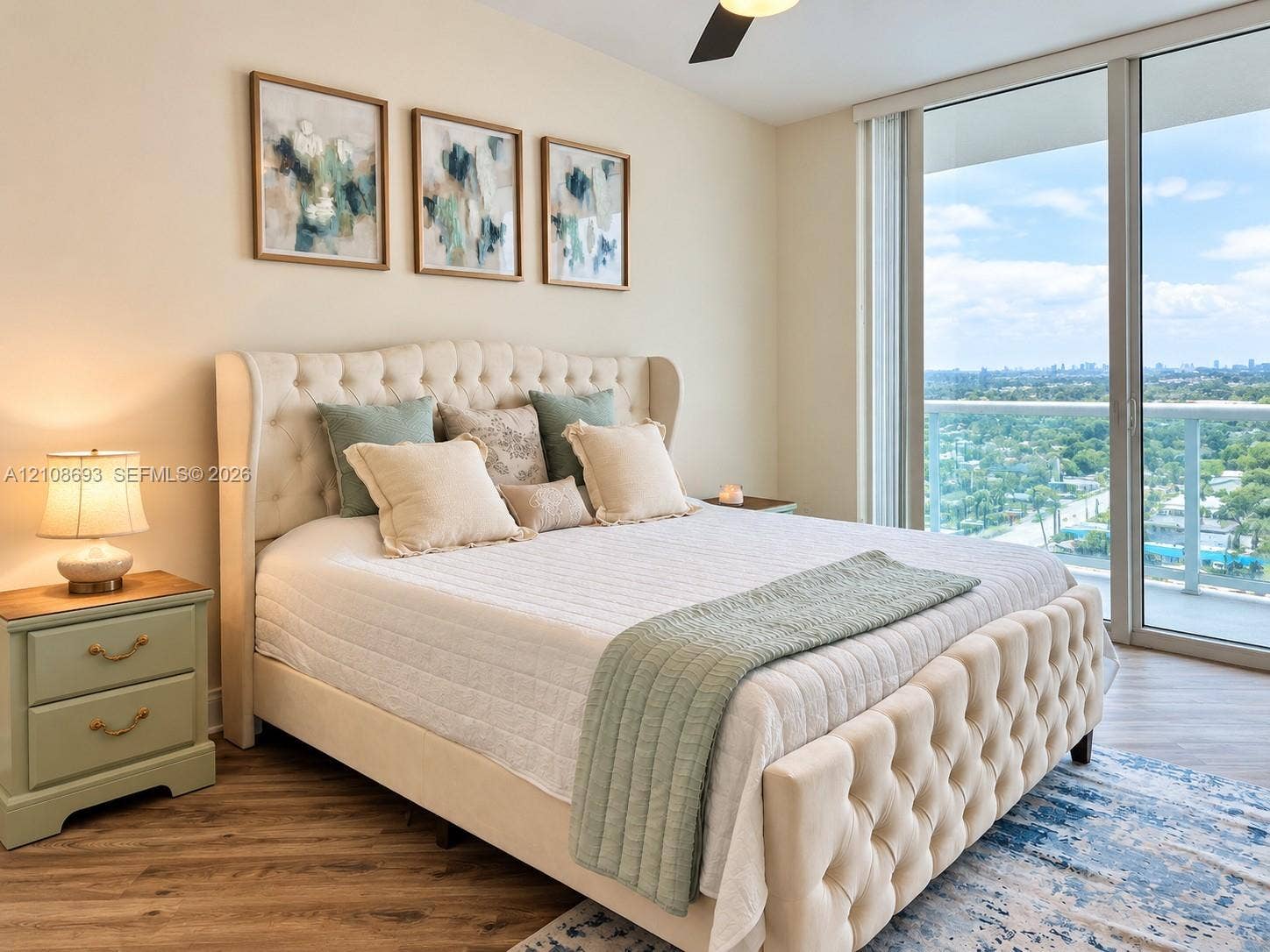 231 Riverside Drive, #1210, Daytona Beach, Daytona Beach, FL 32117 Floor-to-ceiling glass sliding doors, wood-finish flooring, and a ceiling-mounted light fixture with fan
