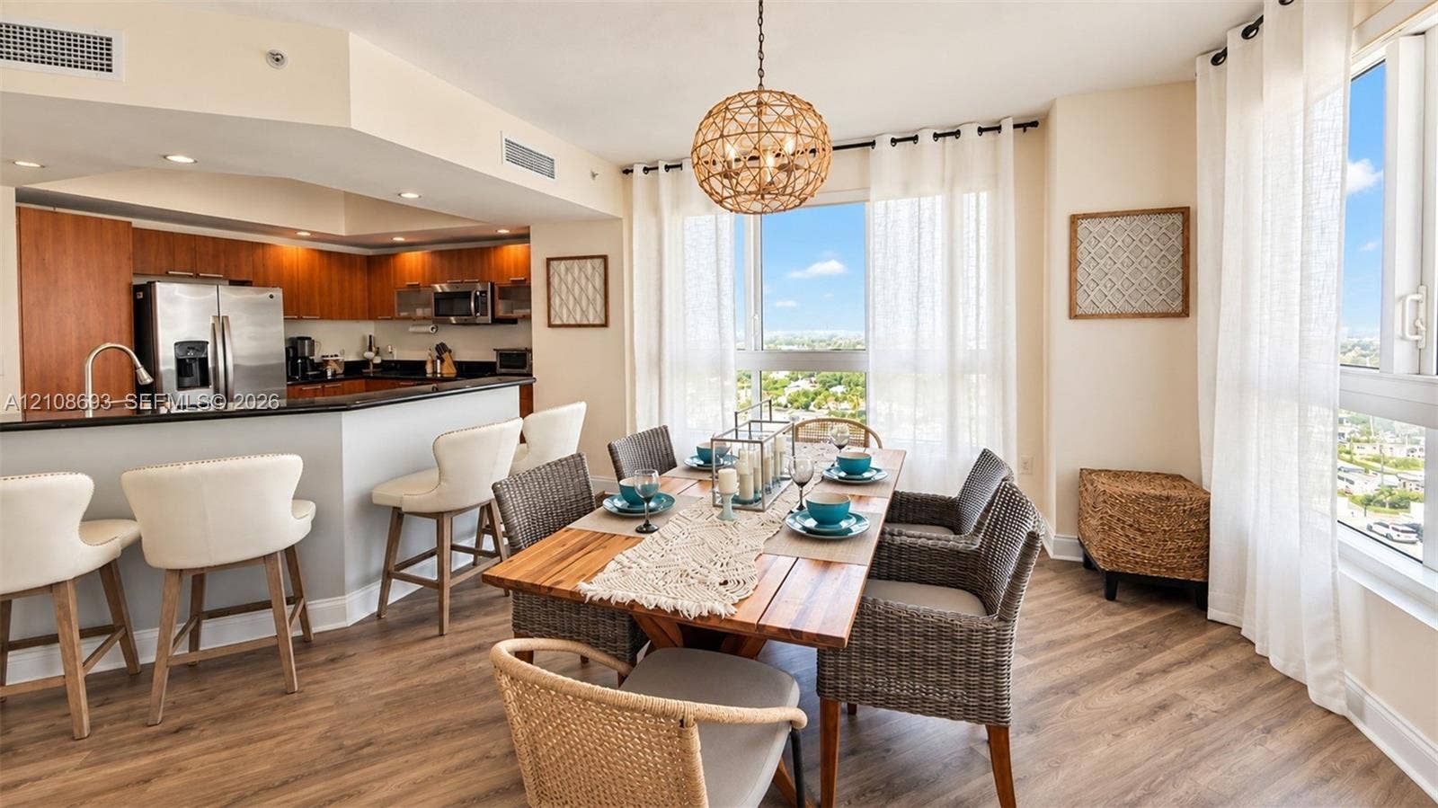 231 Riverside Drive, #1210, Daytona Beach, Daytona Beach, FL 32117 Open-concept kitchen and dining area featuring wood-finish flooring, a kitchen island with stone countertop, stainless steel appliances, and floor-to-ceiling windows