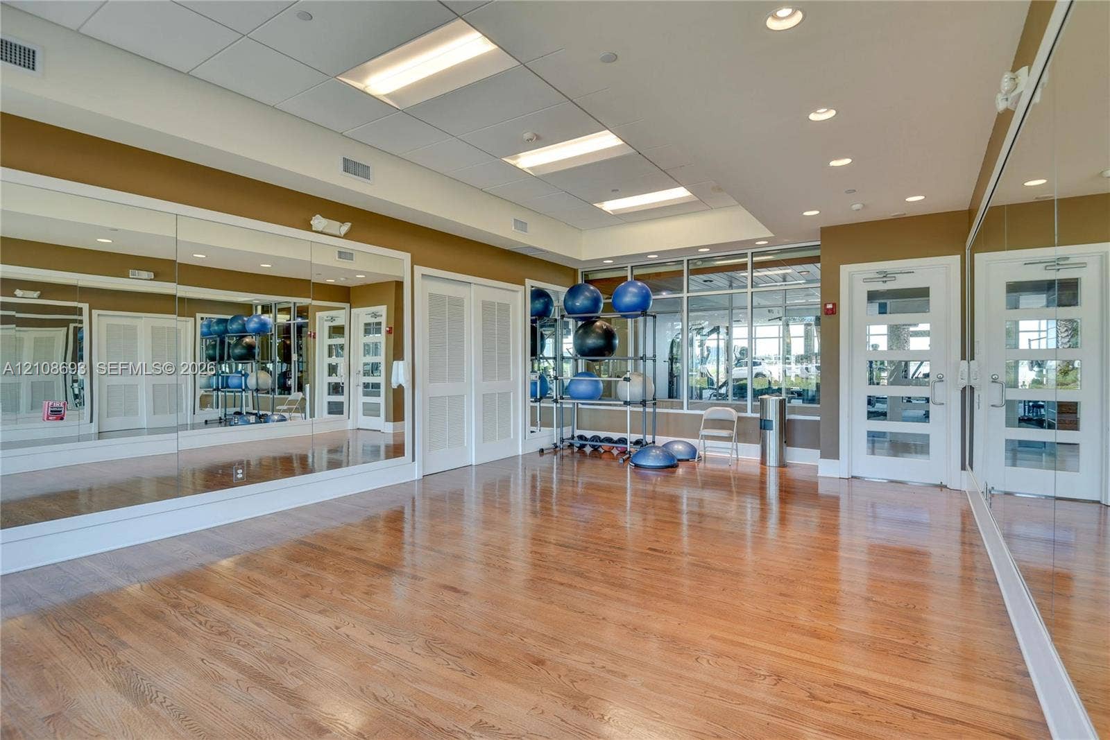 231 Riverside Drive, #1210, Daytona Beach, Daytona Beach, FL 32117 Fitness studio featuring wood-finish flooring, extensive wall-mounted mirrors, recessed lighting, and large windows
