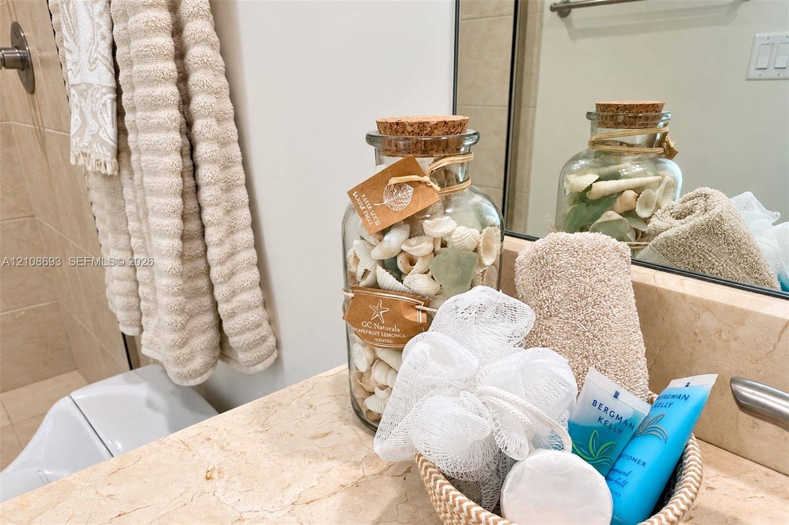 231 Riverside Drive, #1210, Daytona Beach, Daytona Beach, FL 32117 Natural stone vanity countertop with an integrated backsplash and wall-mounted vanity mirror