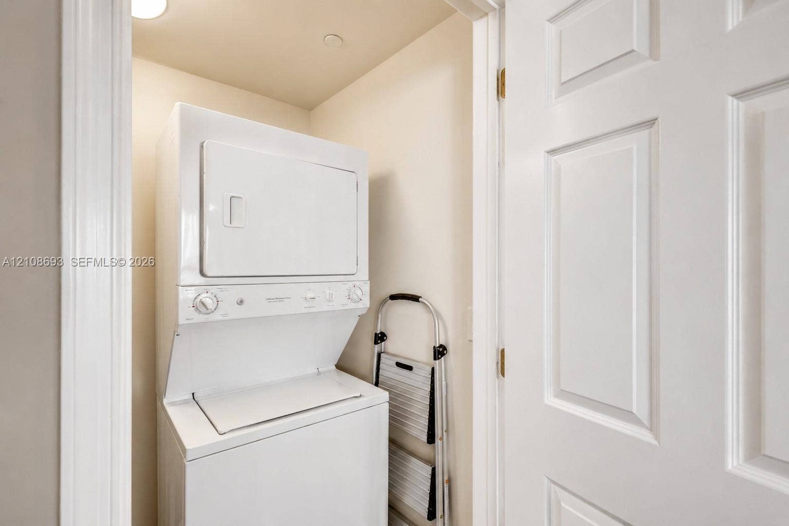 231 Riverside Drive, #1210, Daytona Beach, Daytona Beach, FL 32117 Stacked laundry unit enclosed within a dedicated utility closet featuring a white paneled door