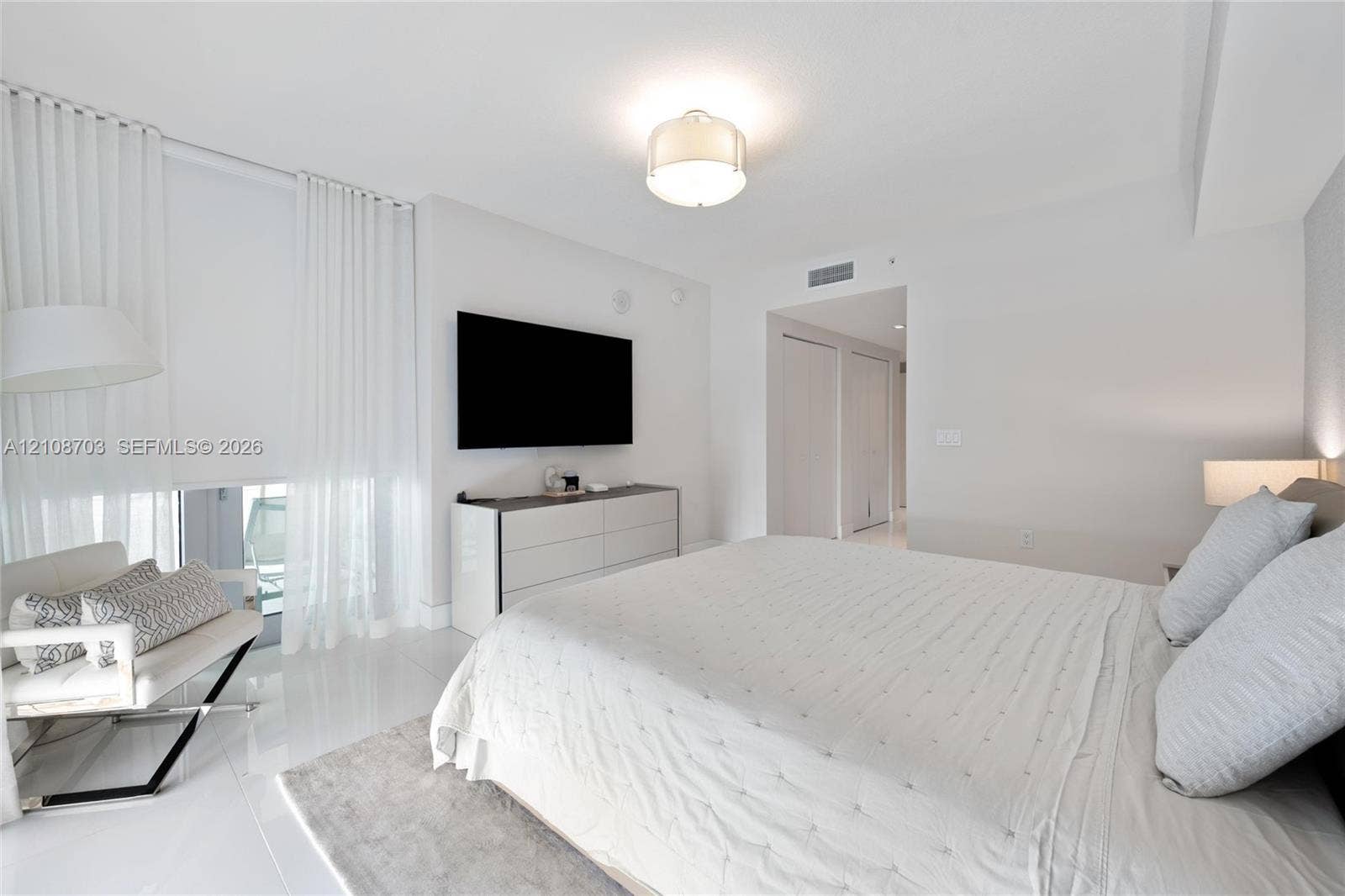 300 Sunny Isles Boulevard, #4-1501, Sunny Isles Beach, Sunny Isles Beach, FL 33160 Bright bedroom featuring high-gloss tile flooring, floor-to-ceiling sheer window treatments, and a contemporary drum-style ceiling fixture