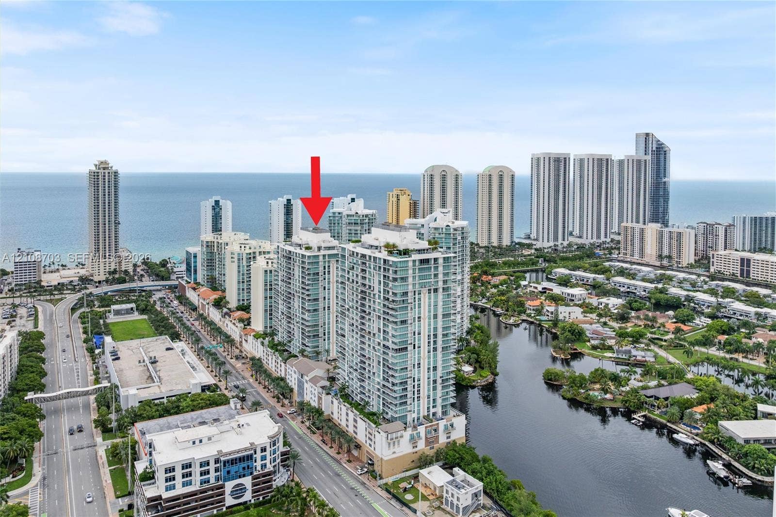 300 Sunny Isles Boulevard, #4-1501, Sunny Isles Beach, Sunny Isles Beach, FL 33160 Aerial perspective of a high-rise residential building featuring floor-to-ceiling glass windows, multiple private balconies, and a coastal location