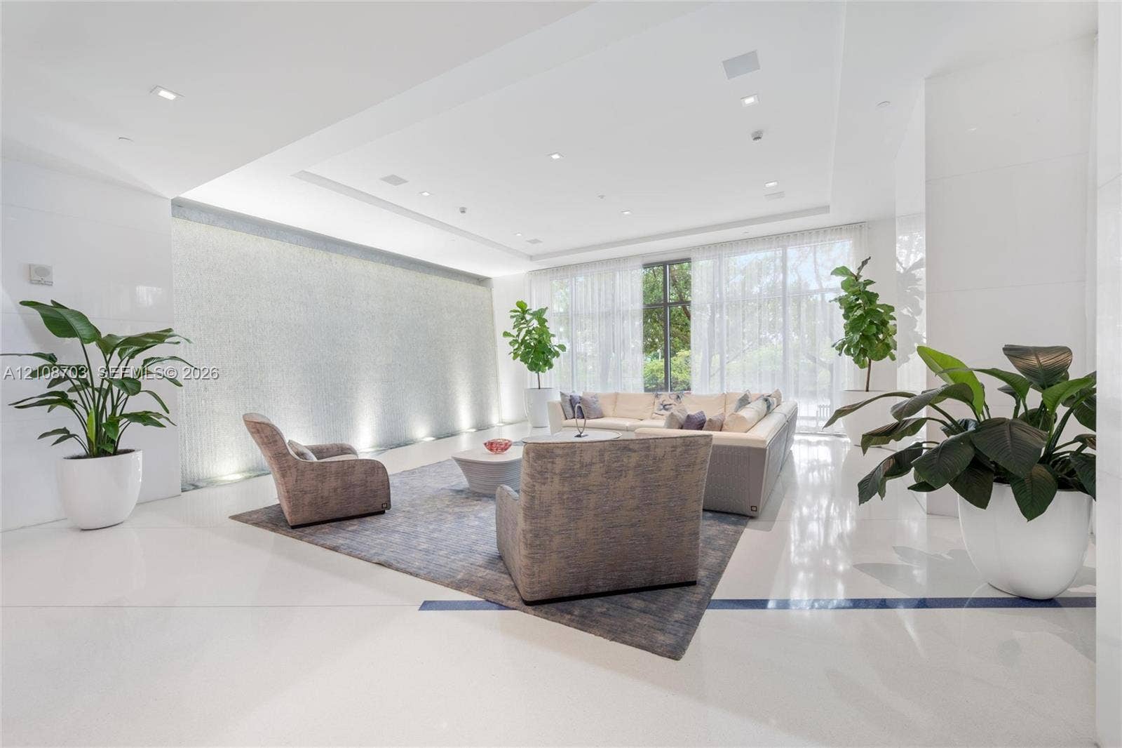 300 Sunny Isles Boulevard, #4-1501, Sunny Isles Beach, Sunny Isles Beach, FL 33160 Expansive lobby featuring polished stone flooring, a full-height decorative tiled water feature with recessed accent lighting, recessed ceiling lighting, and floor-to-ceiling windows