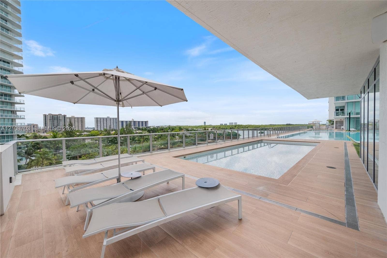 300 Sunny Isles Boulevard, #4-1501, Sunny Isles Beach, Sunny Isles Beach, FL 33160 Private terrace featuring a rectangular swimming pool, wood-finish tile flooring, and a glass-paneled railing
