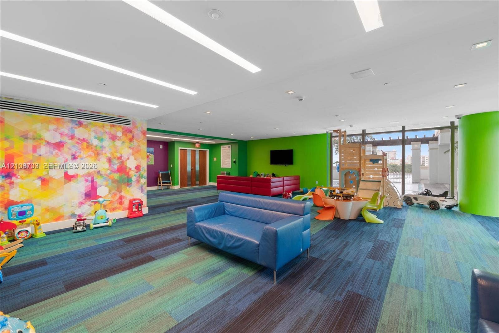 300 Sunny Isles Boulevard, #4-1501, Sunny Isles Beach, Sunny Isles Beach, FL 33160 Open-concept interior space featuring recessed linear lighting, multi-toned carpeted flooring, full-height glass doors, and a decorative patterned accent wall