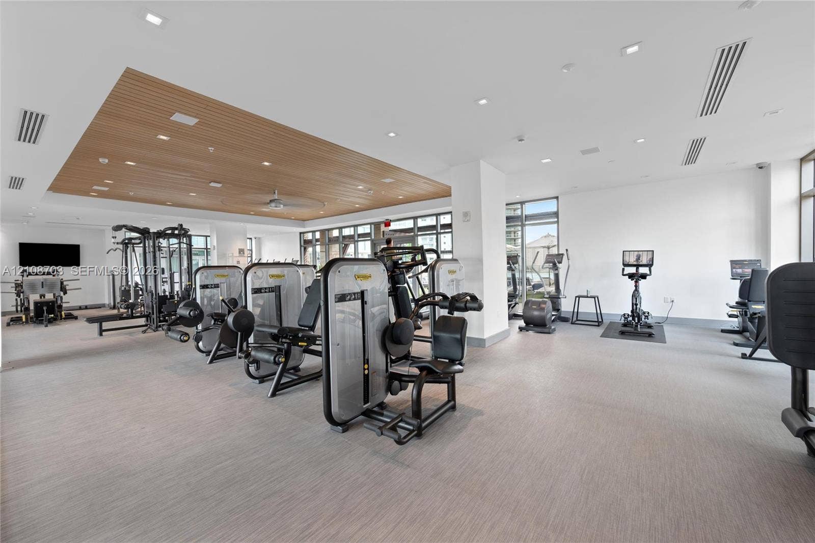 300 Sunny Isles Boulevard, #4-1501, Sunny Isles Beach, Sunny Isles Beach, FL 33160 Fitness center featuring a recessed wood-paneled ceiling, integrated recessed lighting, neutral textured flooring, and large-format glass windows