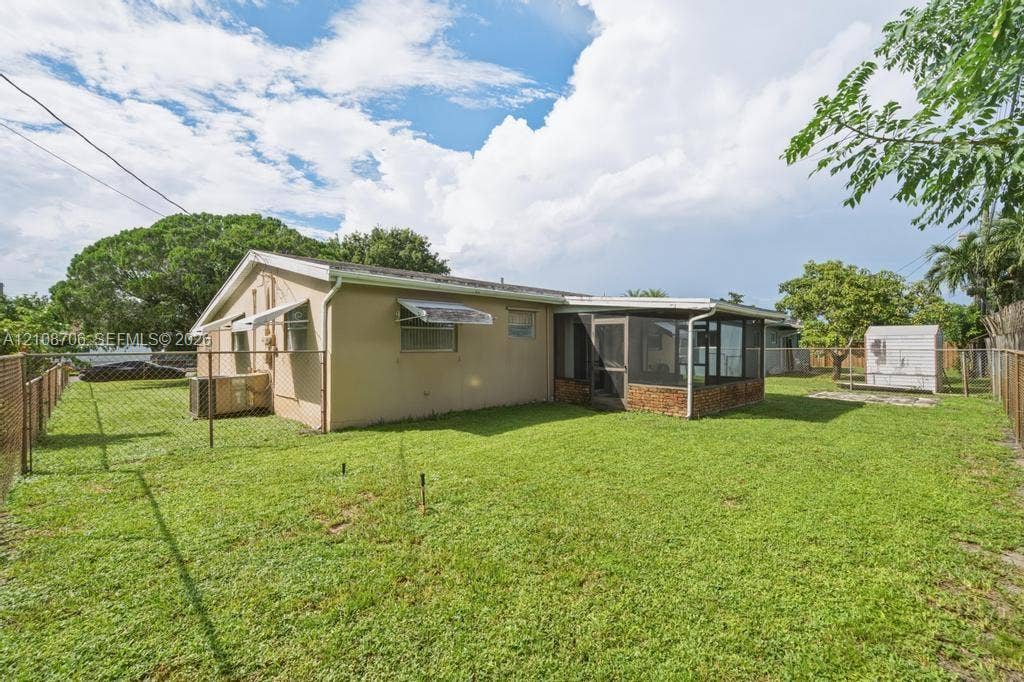 531 N 70th Way, Hollywood, FL 33024 Expansive backyard featuring a fenced perimeter, a screened-in patio, and mature landscaping