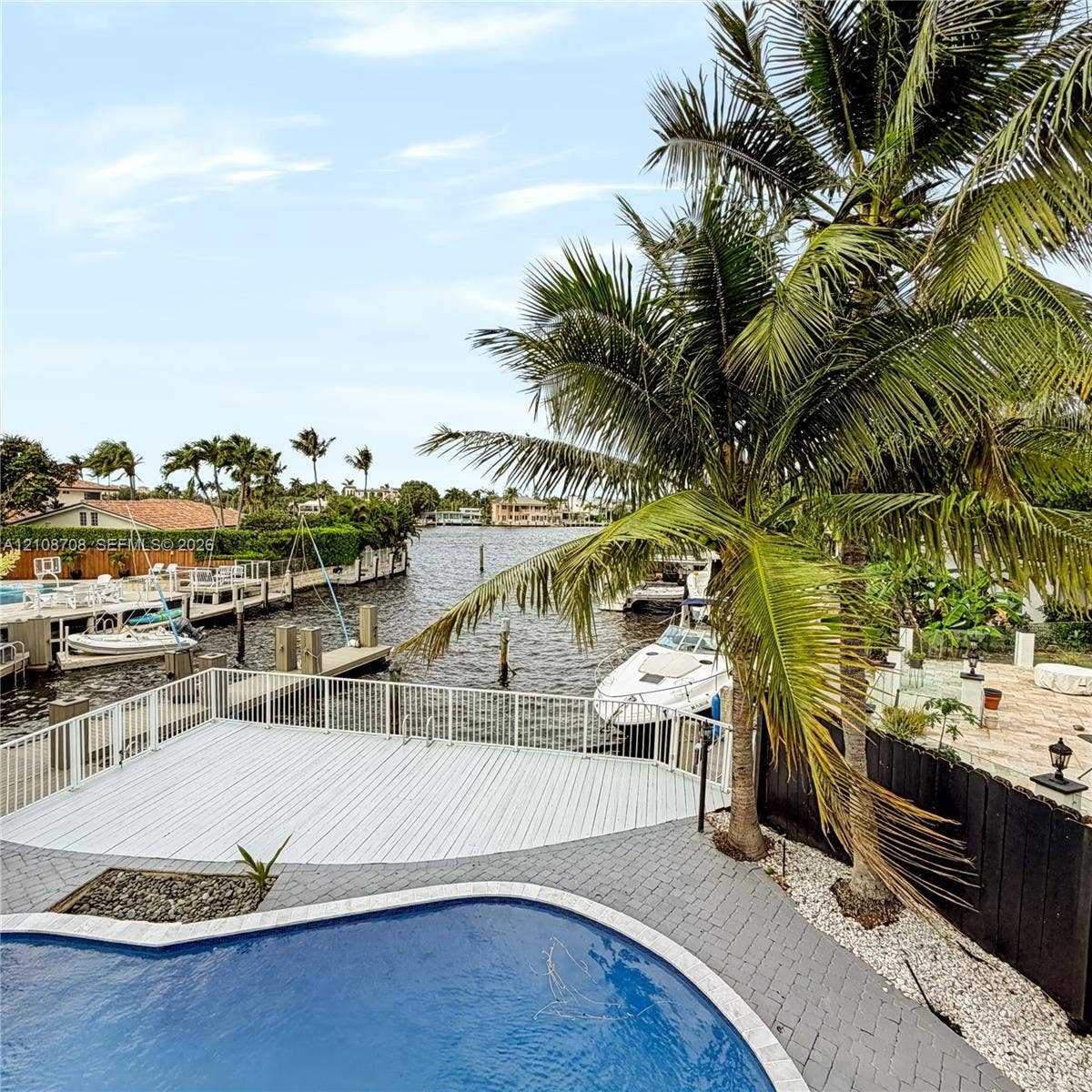 Balcony view over the pool, private dock and wide canal