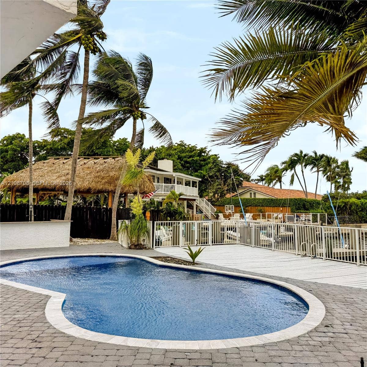 Free form pool with tiki hut and tropical palms