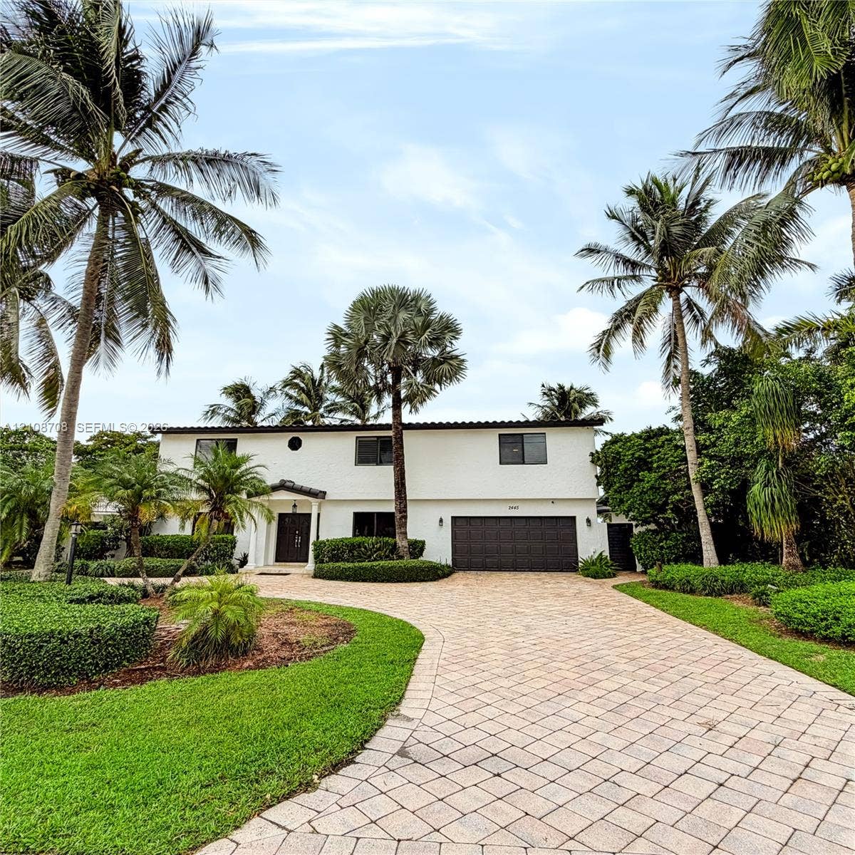 Front of the home with paver driveway and garage